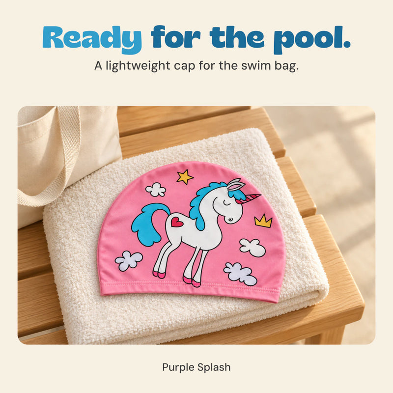 Pink unicorn swim cap resting on a folded towel beside a cream swim bag.