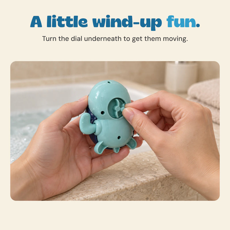 Hands turn the recessed wind-up dial underneath an aqua turtle bath toy.