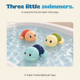 The three included plastic wind-up turtles float in shallow bath water, showing their blue, orange and green shells.