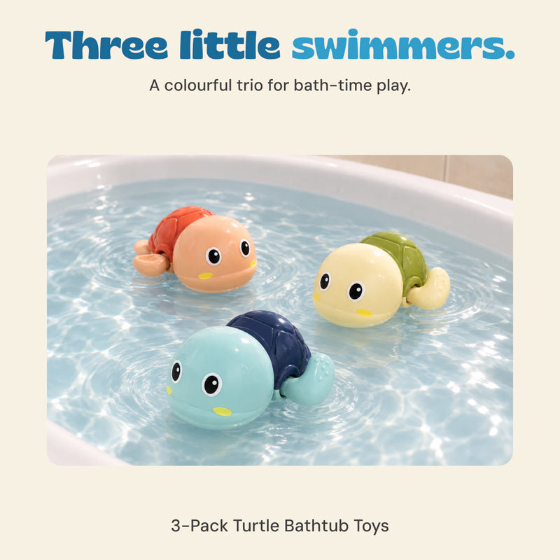 The three included plastic wind-up turtles float in shallow bath water, showing their blue, orange and green shells.