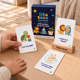 An adult naturally holds an I can try again affirmation card beside a child's resting hand. Updated Brave & Growing packaging with green Courage & Resilience subtitle and wooden stand. Generated lifestyle mockup.