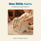 The original product photograph shows a child reaching toward the spinning drum during floor play.