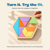 A hand lifts the pale green triangle above its matching space in the Pastel Shape Board.